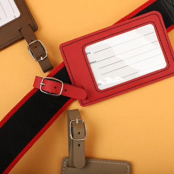 Leather luggage tags in red colors. Concept shot, top view. Custom background, luggage tags view. Empty Travel Luggage Label, Space blank for text.
