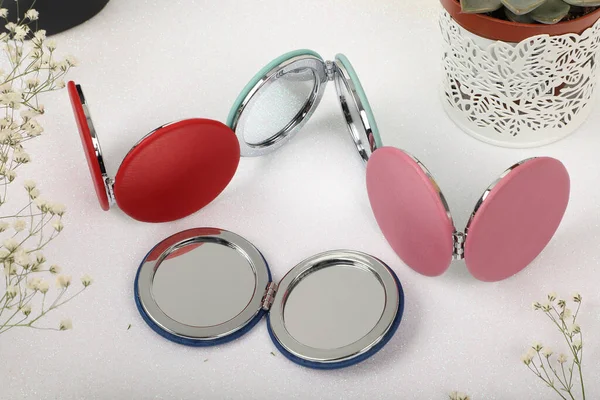 Leather Round pocket makeup mirror in different colors. Concept shot, top view. Custom background, pocket makeup mirror. Travel pocket mirror,  Colorful mini mirror.