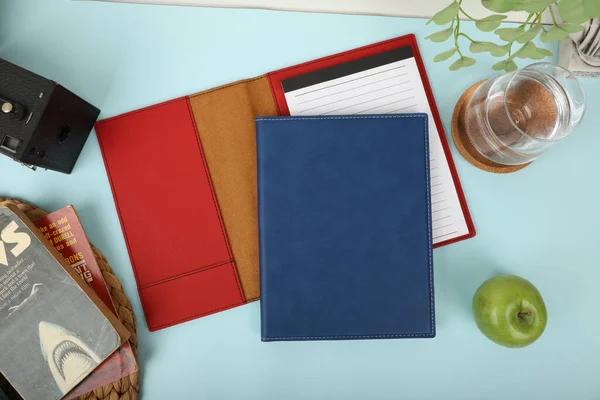 Leather portfolio. Concept shot, top view, portfolio in blue and red colors. Custom background flap portfolio view. Portfolio and accessories. Notepad for sketching. Notebook with leather cover. Notepad Holder or Leather Organizer.