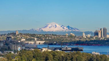 Bu yüksek çözünürlüklü görüntü, Kuzey Vancouver 'da yükselen Baker Dağı' nın karla kaplı zirvesini yakalıyor. Önplanda, canlı şehir modern kuleler, yerleşim bölgeleri ve sanayi kıyılarından oluşur..