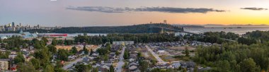 Bu panoramik görüntü Vancouver 'ı gün batımında şehir merkezindeki siluet, Lions Gate Bridge, Stanley Park ve yakınlardaki yerleşim bölgeleriyle yakalıyor. Parlayan gökyüzü ve kıyı suları sakin, dengeli bir şehir doğası tonu oluşturur..
