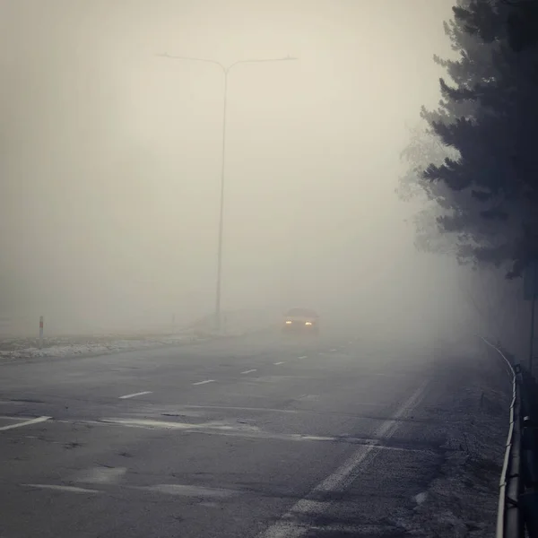 Cars in the fog. Traffic on the road in winter in bad weather. Dangers of driving cars.