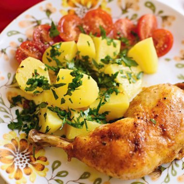 Tavuk budu ve beyaz tabakta kızarmış patates.