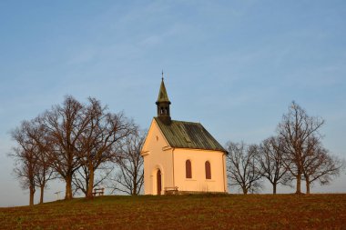 Ağaçları ve mavi gökyüzü olan küçük güzel bir kilise. Brno-Lisen - Çek Cumhuriyeti. Meryem Ana 'nın Şapeli Hıristiyanların Yardımı