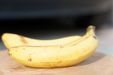 Tahta arka planda sarı olgun muzlar