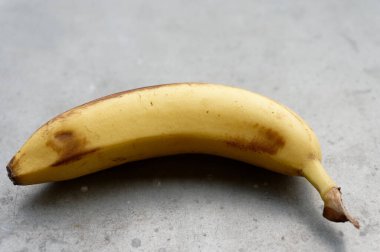 Gri arka planda sarı muz. Taze olgun muzlar.