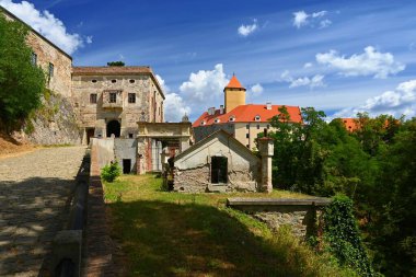 Güzel Gotik şato Veveri. Brno barajındaki Brno şehri. Güney Moravya - Çek Cumhuriyeti - Orta Avrupa. Şatosu, ormanı, gökyüzü, bulutları ve gökyüzünde güneşi olan bir manzara. Yaz mevsiminde doğa.