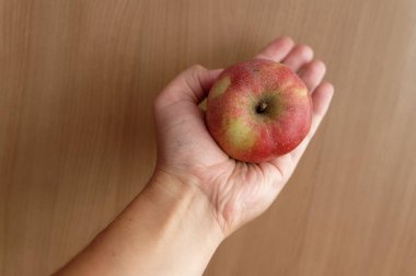 Beyaz arka planda kırmızı elmayı tutan kadın.