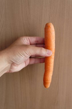 Elinde taze havuç tutan kadın.