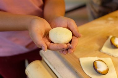 Çocuk ahşap bir tahtada turta kesiyor, yakın plan.