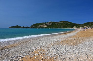 Deniz, güneş ve mavi gökyüzü olan güzel bir sahil. Seyahat ve yaz tatili kavramı. Yunanistan-Korfu adası. Agios Georgios plajı