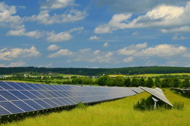 Güneş enerjisi santrali - elektrik ve ekoloji endüstrisi konsepti. Yüksek enerji fiyatları. Güzel bir manzara ve mavi gökyüzü ile güneşli bir gün. Fotovoltaik enerji santrali.