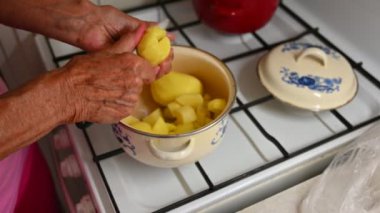 Kadın mutfakta patates pişiriyor.
