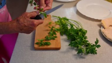 Kadının elleri mutfaktaki taze soğanı kesiyor..