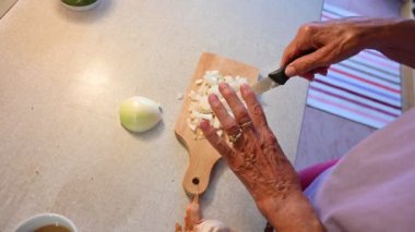 Son sınıf öğrencisi salata yapmak için soğan doğruyor..