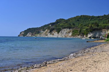 Deniz, güneş ve mavi gökyüzü olan güzel bir sahil. Seyahat ve yaz tatili kavramı. Yunanistan-Korfu Adası.