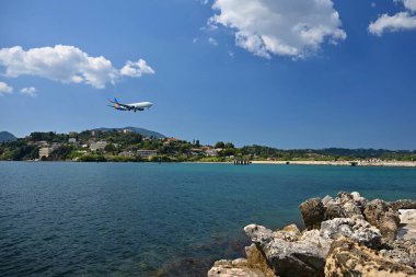 Deniz kıyısındaki havaalanları ve suya inen uçaklar. Uçak izleme noktası. Korfu Adası Yunanistan. Tatil, seyahat ve uçak yolculuğu kavramı.