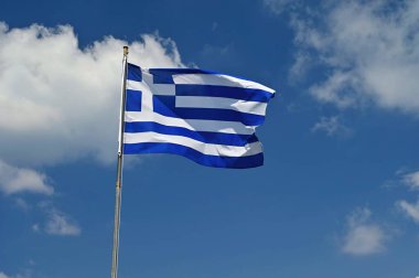 Yunanistan Bayrağı Rüzgarda ve Mavi Gökte Dalgalanıyor. Seyahat ve tatil için yaz arkaplanı.