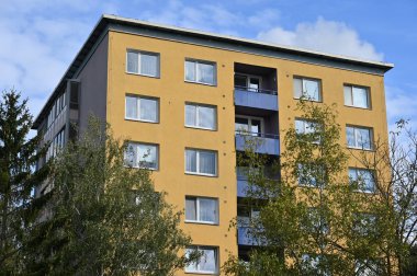 Orijinal prefabrik evler Doğu ve Orta Avrupa 'daki komünist dönemden kalma bir konut arazisinde yeniden inşa edildikten sonra.. Pencereleri ve balkonları olan modern bir apartmanın cephesi. Çek Cumhuriyeti - Avrupa.