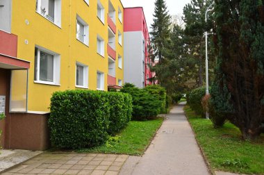 Pencereleri ve balkonları olan modern bir apartmanın ön cephesi. 