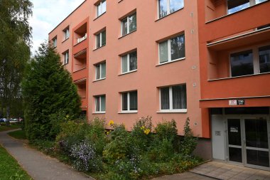 Pencereleri ve balkonları olan modern bir apartmanın ön cephesi. 