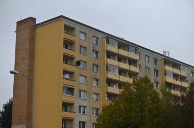 Pencereleri ve balkonları olan modern bir apartmanın ön cephesi. 