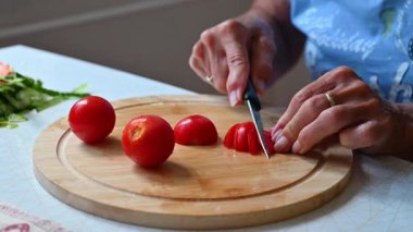 Mutfakta sebze doğrayan ve hazırlayan bir kadın. Yemek ve yemek hazırlama kavramı.