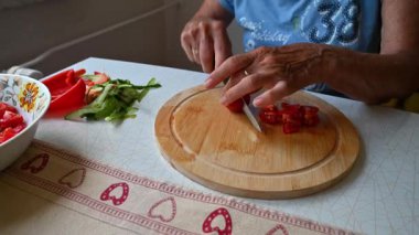 Mutfakta sebze doğrayan ve hazırlayan bir kadın. Yemek ve yemek hazırlama kavramı.