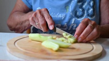Mutfakta sebze doğrayan ve hazırlayan bir kadın. Yemek ve yemek hazırlama kavramı.