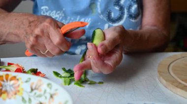 Mutfakta sebze doğrayan ve hazırlayan bir kadın. Yemek ve yemek hazırlama kavramı.