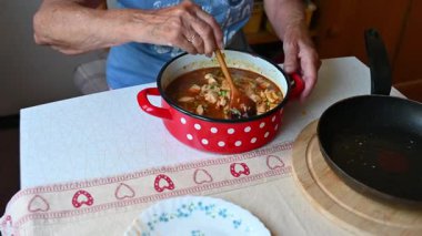 Bir kadın mutfakta et yemeği hazırlıyor. Yemek ve yemek hazırlama kavramı..