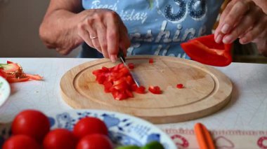 Mutfakta sebze doğrayan ve hazırlayan bir kadın. Yemek ve yemek hazırlama kavramı.