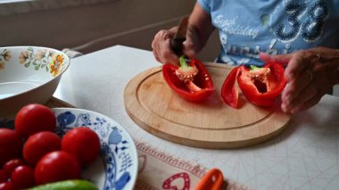 Mutfakta sebze doğrayan ve hazırlayan bir kadın. Yemek ve yemek hazırlama kavramı.