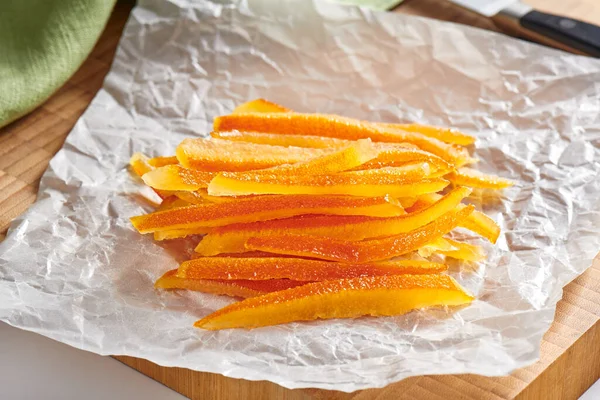 しわのあるベーキングペーパー上の砂糖漬けのオレンジの皮 — ストック写真
