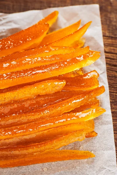 しわのあるベーキングペーパー上の砂糖漬けのオレンジの皮 — ストック写真