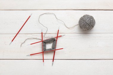 Çemberin içinde çift taraflı örgü iğneleri ve iplik yumağıyla örme işlemi..