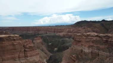 Aşağıdaki nehir vadisi olan Charyn Canyon Vadisi. Bulutlu gökyüzünün arka planında