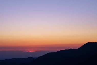 Güneş doğmadan önce bir dağ siluetinin silueti. Mavi saat                               