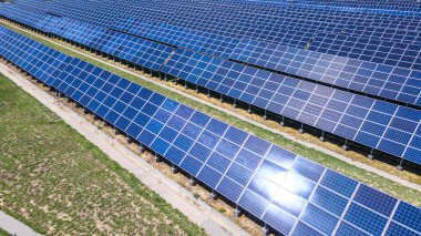 Güneş yansıması olan bir enerji santralinde fotovoltaik modüller. Yeşil enerji