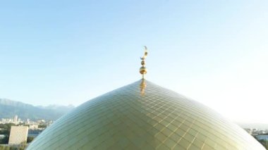 Almaty, Kazakistan - 17 Ağustos 2023: Şehrin arka planında hilal şeklinde ay bulunan büyük altın bir kubbe. Merkezi cami.