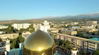 Almaty, Kazakistan - 17 Ağustos 2023: Şehrin arka planında hilal şeklinde bir ay olan caminin merkezi kubbesi. Bir İHA görüntüsü