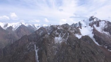 Karla kaplı dağların panoramik manzarası. Bulutlu hava