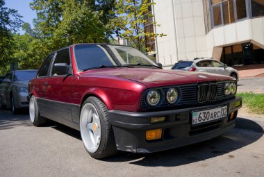 Almaty, Kazakistan - 25 Ağustos 2023: eski bir BMW 3 Serisi Coupe 'nin önü bordo. Sokak otoparkı