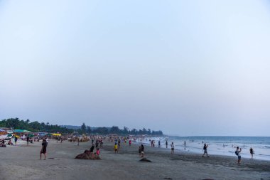 GOA, Hindistan - 27 Şubat 2024: İnsanlar Arap Denizi kıyısında akşamları dinleniyor. Tatil zamanı.
