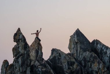 GOA, Hindistan - 27 Şubat 2024: Uçurumların birinde yoga yapan bir adam. Ruhani uygulama.