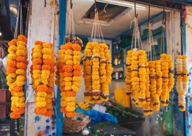 Markette renkli kadife çiçekleri asılı. Mala