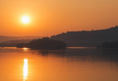 Yükselen güneş deniz kıyısına yansıyor. Altın saat