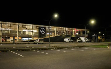 Almaty, Kazakistan - 18 Ekim 2024: Mercedes Benz bayiliğinin önüne park etmek. Resmi dağıtımcı. Gece vakti.                     