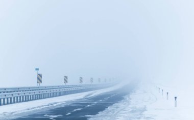 Yoğun sis sırasında karlı bir yol. Kış havası