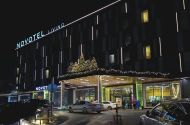 Almaty, Kazakistan - 18 Ocak 2025: Geceleyin Novotel 'in merkez girişi. Yeni yıl süslemeleri                               